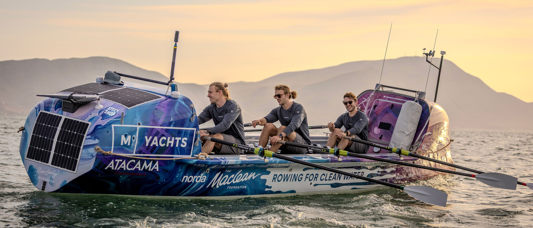 The Maclean brothers row on the ocean at sunset